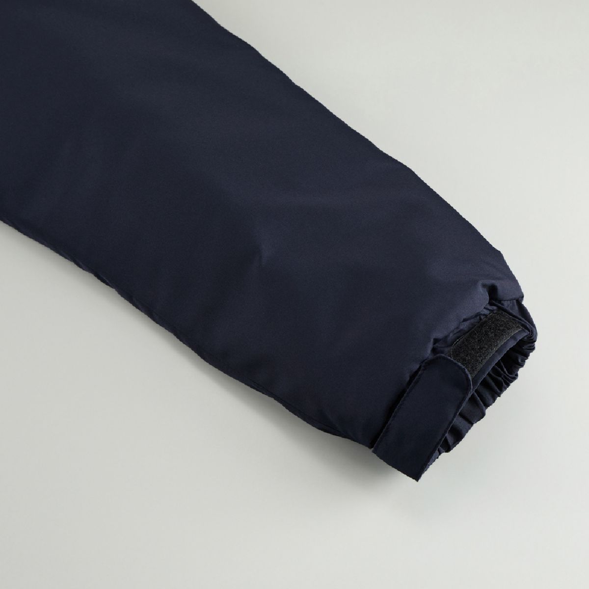 The cuffs feature shirring and hook-and-loop fasteners.